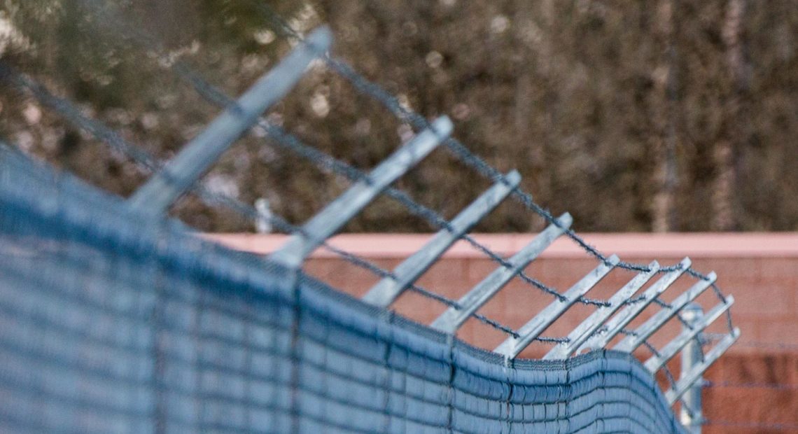 A barbed wire fence encloses the Columbia County Jail yard in St. Helens, Ore., Saturday, March 30, 2019. CREDIT: Bradley Parks/OPB