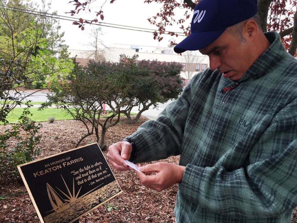 Fred Farris reads a note left at a memorial for his son Keaton who died in the Island County Jail in 2015. CREDIT: AUSTIN JENKINS/N3