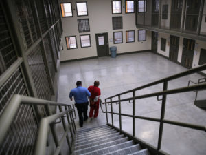 A guard escorts a detained immigrant from his "segregation cell" back into the general population at the Adelanto Detention Facility in November 2013. Today the privately run ICE facility in Adelanto, Calif., houses nearly 2,000 men and women and has come under sharp criticism by the California attorney general and other investigators for health and safety problems. CREDIT: John Moore/Getty Images