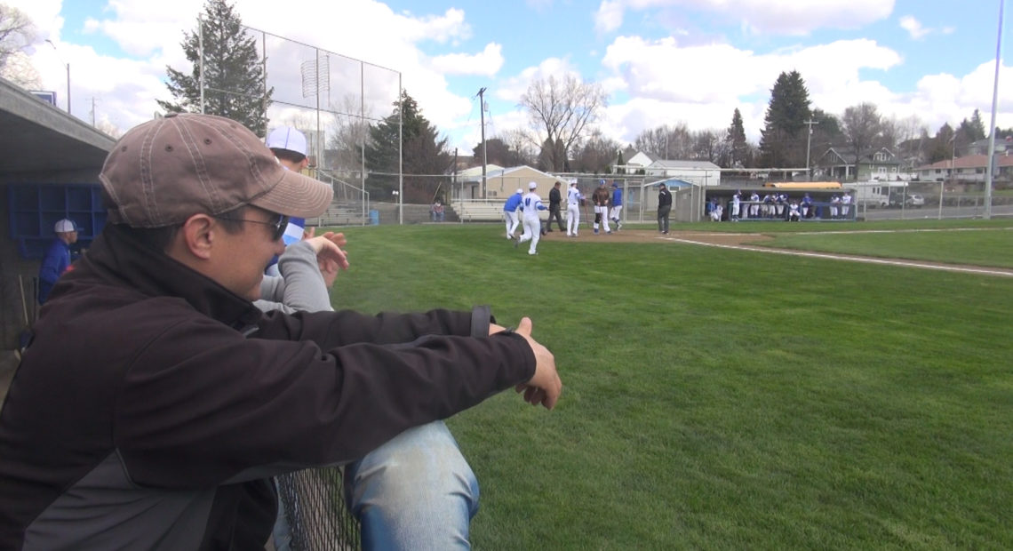 Certified Athletic Trainer Kai Seshiki watches Colton high school athletes take the field for a baseball game.