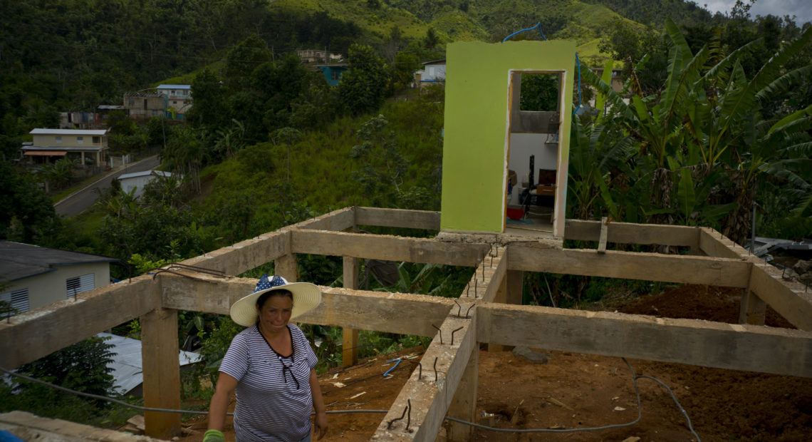 Alma Morales Rosario stands between the beams of her home, in the San Lorenzo neighborhood of Morovis, Puerto Rico, which was being rebuilt in September 2018 after being destroyed by Hurricane Maria. CREDIT: Ramon Espinosa/AP