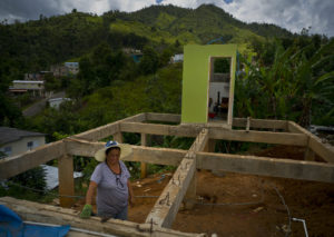 Alma Morales Rosario stands between the beams of her home, in the San Lorenzo neighborhood of Morovis, Puerto Rico, which was being rebuilt in September 2018 after being destroyed by Hurricane Maria. CREDIT: Ramon Espinosa/AP
