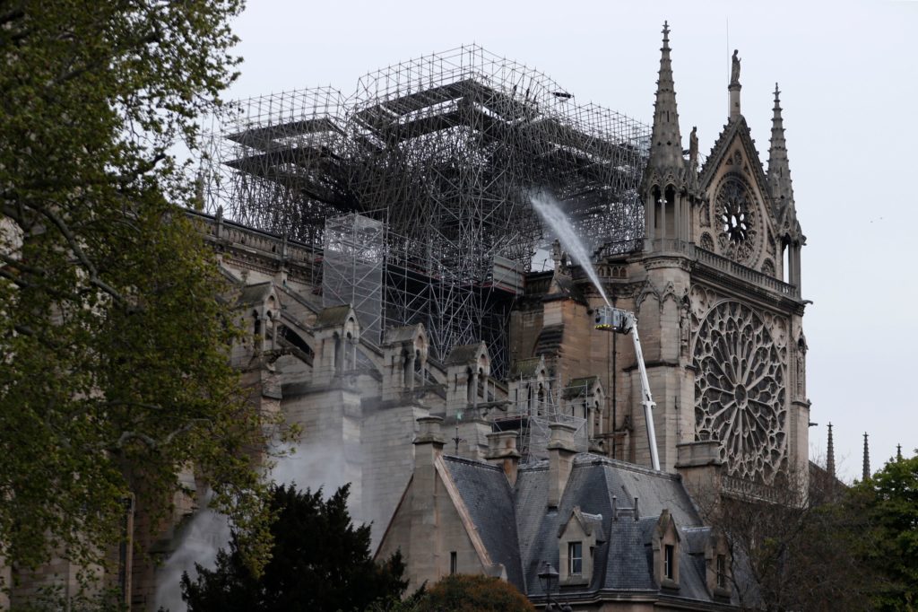 Firefighters spray water as they work to extinguish a fire at Notre-Dame Cathedral in Paris early on Tuesday. A huge fire that devastated Notre Dame Cathedral is "under control", the Paris fire brigade said after firefighters spent hours battling the flames. Zakaria Abdelkafi/AFP/Getty Images