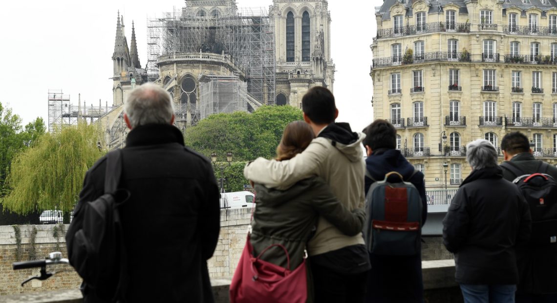 People hug while looking at Notre Dame Cathedral in the aftermath of a fire that devastated the cathedral. Bertrand Guay/AFP/Getty Images