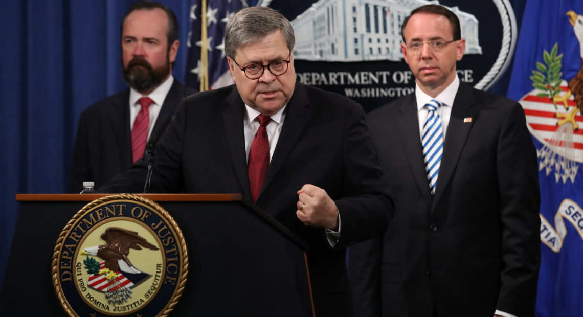 Attorney General William Barr speaks about the redacted version of the Mueller report as U.S. Deputy Attorney General Rod Rosenstein (right) and U.S. Acting Principal Associate Deputy Attorney General Ed O'Callaghan listen at the Department of Justice Thursday before the document's release. CREDIT: Win McNamee/Getty Images