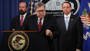 Attorney General William Barr speaks about the redacted version of the Mueller report as U.S. Deputy Attorney General Rod Rosenstein (right) and U.S. Acting Principal Associate Deputy Attorney General Ed O'Callaghan listen at the Department of Justice Thursday before the document's release. CREDIT: Win McNamee/Getty Images