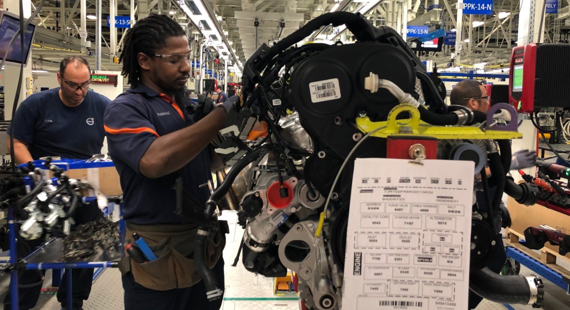 Tremaine Smalls attaches parts to an engine at Volvo's plant in Ridgeville, S.C. The automaker has shifted its exports to Europe as the result of the U.S. trade war with China. CREDIT: Camila Domonoske/NPR