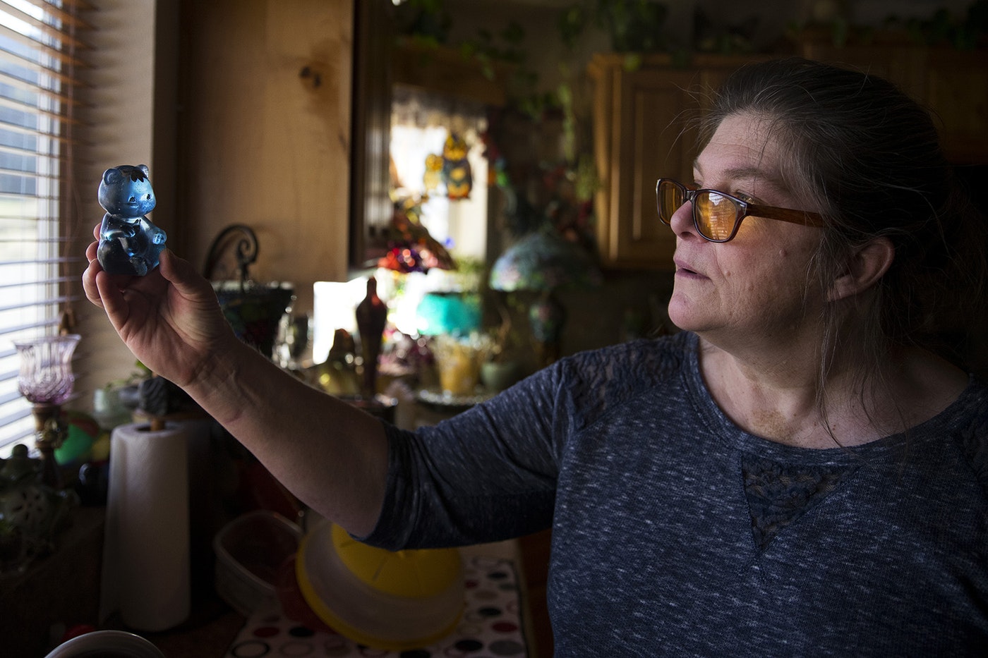 Dagmar Devere holds a fenton bear up to the light on Tuesday, April 23, 2019, at her home near Pateros, Washington. Devere lost everything, including her home, in the Carlton Complex Fire and the fenton bear was the only thing that survived. CREDIT: KUOW PHOTO/MEGAN FARMER