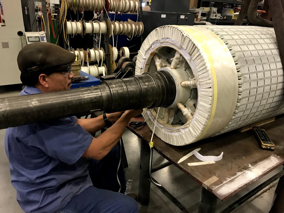In H&N Electric's shop, Jose Gutierrez finishes up one of the last steps of repairing a part of a wind turbine generator. CREDIT: COURTNEY FLATT/NWPB
