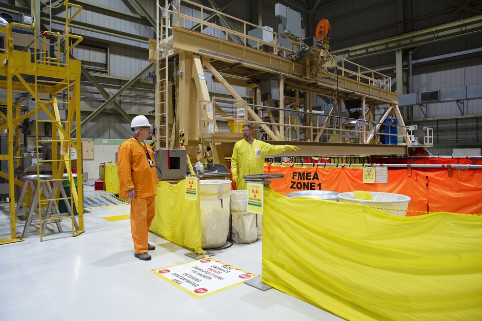 Workers at Peach Bottom stand near the deep pools where the waste will cool for seven to 10 years. CREDIT: Olivia Sun/NPR