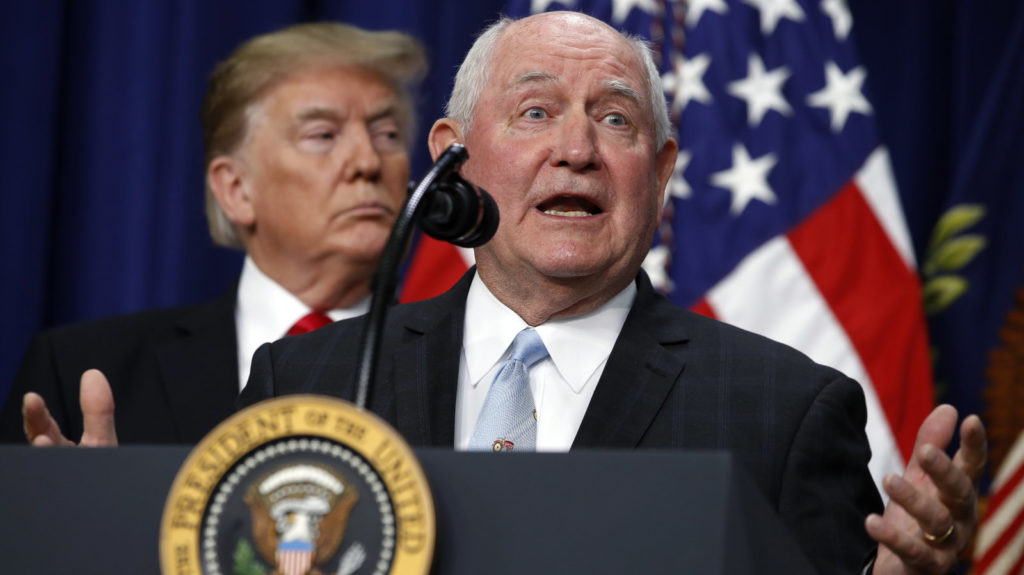 President Trump listens to Agriculture Secretary Sonny Perdue during a signing ceremony. The USDA wants to move two vital research agencies out of Washington D.C. Jacquelyn Martin/AP