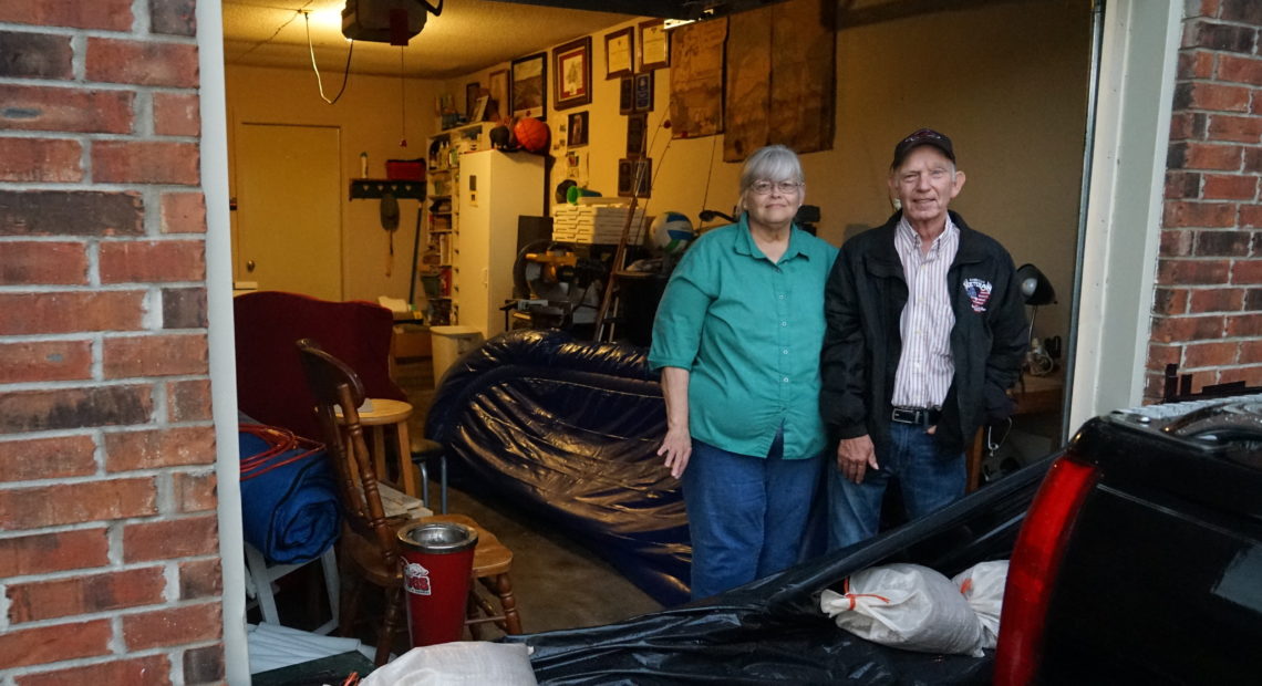 John and Louise Hutchins stand in their garage in Fort Smith, Ark., behind a homemade sandbag barrier. They chose not to evacuate, in part because they did not think their neighborhood would flood. Nathan Rott/NPR