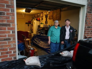John and Louise Hutchins stand in their garage in Fort Smith, Ark., behind a homemade sandbag barrier. They chose not to evacuate, in part because they did not think their neighborhood would flood. Nathan Rott/NPR