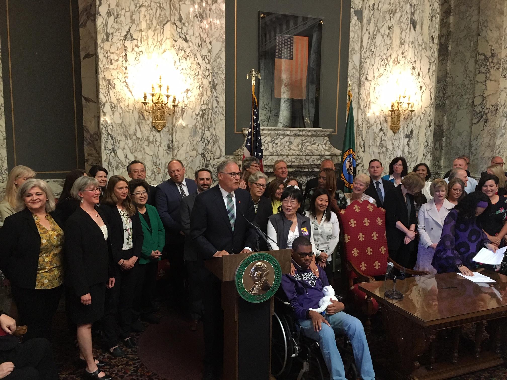 Washington Gov. Jay Inslee signed two historic bills into law on Monday. One creates a public health insurance option, the other a new long-term care benefit. CREDIT: AUSTIN JENKINS / NORTHWEST NEWS NETWORK