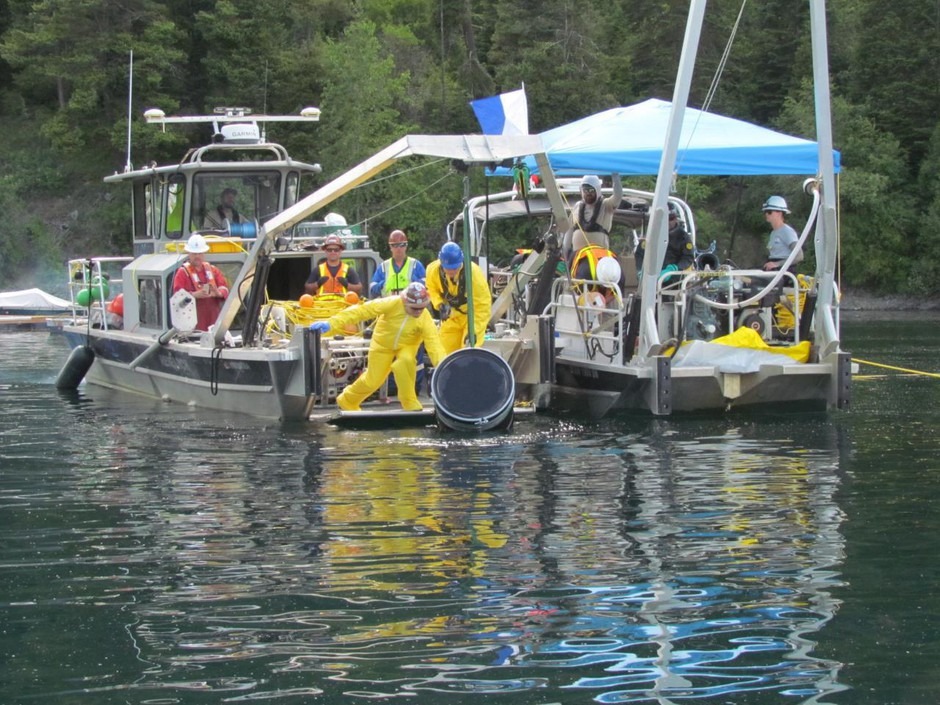 The U.S. EPA removes a barrel that may be contaminated with either of two herbicides from Wallowa Lake. To remove the contaminated barrel, divers place it in a larger, plastic barrel. CREDIT: U.S. EPA