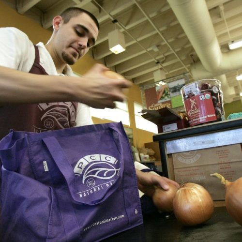 Isaiah McDaniel bags groceries into a customer's cloth bags at PCC Natural Market Tuesday, Jan. 15, 2008, in Seattle. CREDIT: ELAINE THOMPSON/AP
