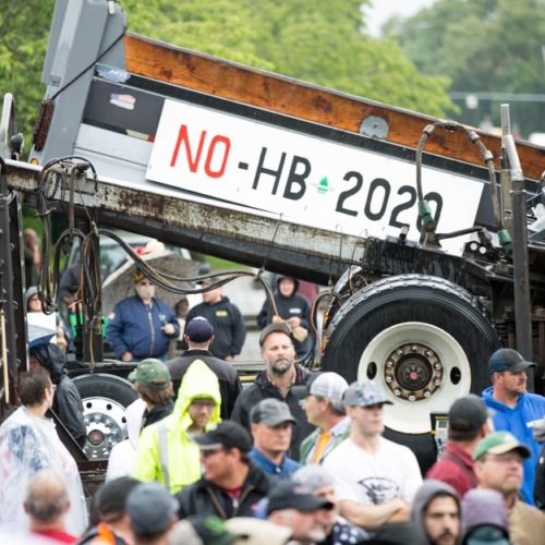 A flatbed truck rides by as a crowd rallies at the Capitol in Salem to protest House Bill 2020. CREDIT: David Stuckey/OPB