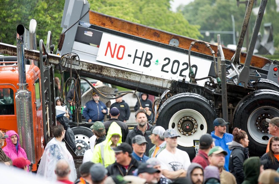 A flatbed truck rides by as a crowd rallies at the Capitol in Salem to protest House Bill 2020. CREDIT: David Stuckey/OPB