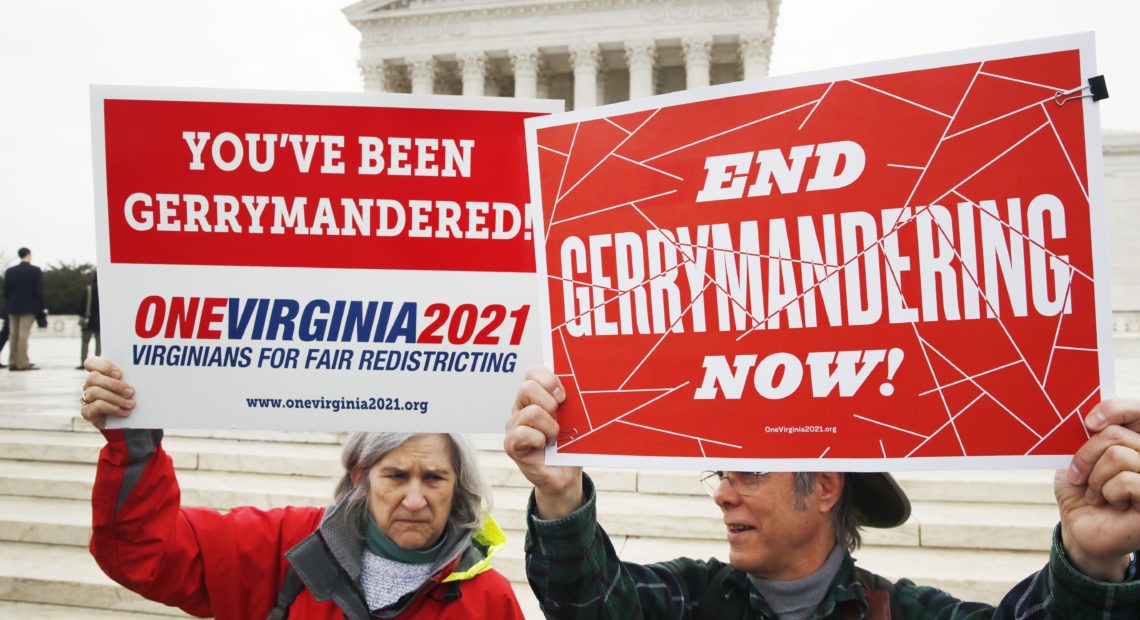 Sara Fitzgerald and Michael Martin, both with the group One Virginia, protest gerrymandering in front of the Supreme Court in March 2018. Jacquelyn Martin/AP