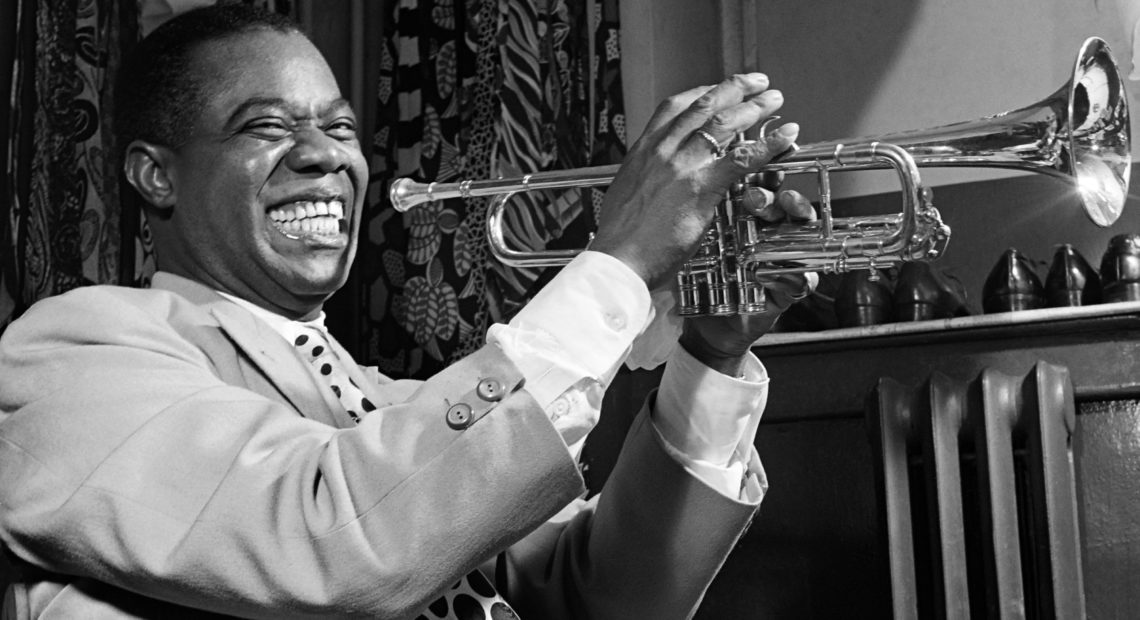 March 1950: Louis Armstrong plays trumpet in his dressing room before a show in New York. CREDIT: AFP/Getty Images