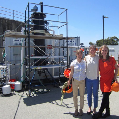 Anne Schauer-Gimenez (from left) Allison Pieja and Molly Morse of Mango Materials stand next to the biopolymer fermenter at a sewage treatment plant next to San Francisco Bay. The fermenter feeds bacteria the methane they need to produce a biological form of plastic. CREDIT: CHRIS JOYCE/NPR