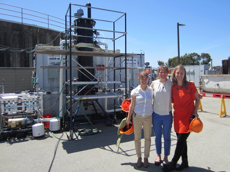 Anne Schauer-Gimenez (from left) Allison Pieja and Molly Morse of Mango Materials stand next to the biopolymer fermenter at a sewage treatment plant next to San Francisco Bay. The fermenter feeds bacteria the methane they need to produce a biological form of plastic. CREDIT: CHRIS JOYCE/NPR