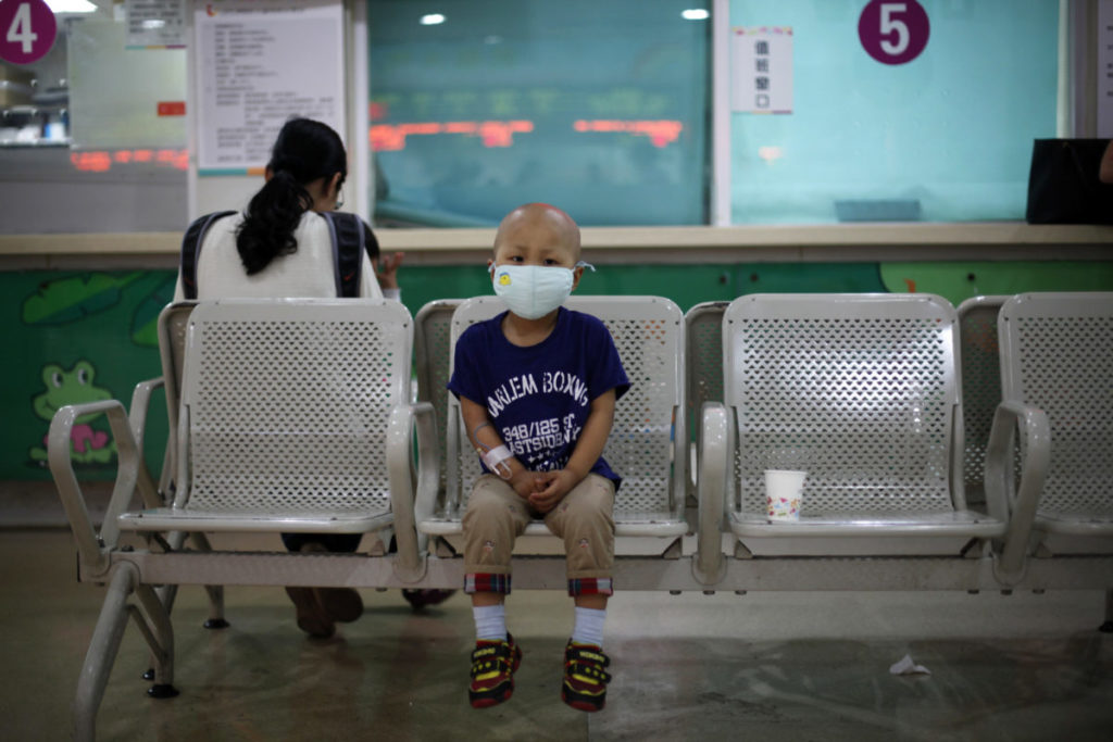 Four-year-old Niuniu, who has late-stage neuroblastoma, a malignant cancer of the nervous system, sits on a bench while his mother pays his medical bills after getting tested for his fifth round of chemotherapy at Shanghai Children's Hospital in 2013. CREDIT: ALY SONG/REUTERS