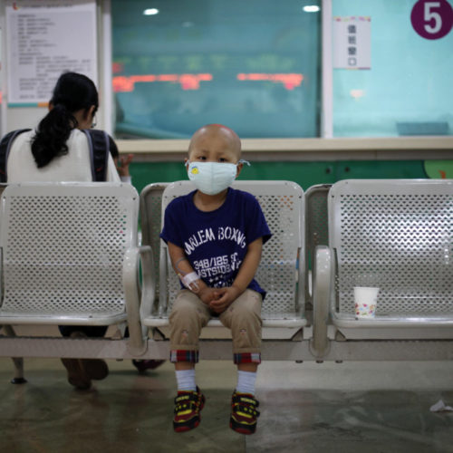 Four-year-old Niuniu, who has late-stage neuroblastoma, a malignant cancer of the nervous system, sits on a bench while his mother pays his medical bills after getting tested for his fifth round of chemotherapy at Shanghai Children's Hospital in 2013. CREDIT: ALY SONG/REUTERS