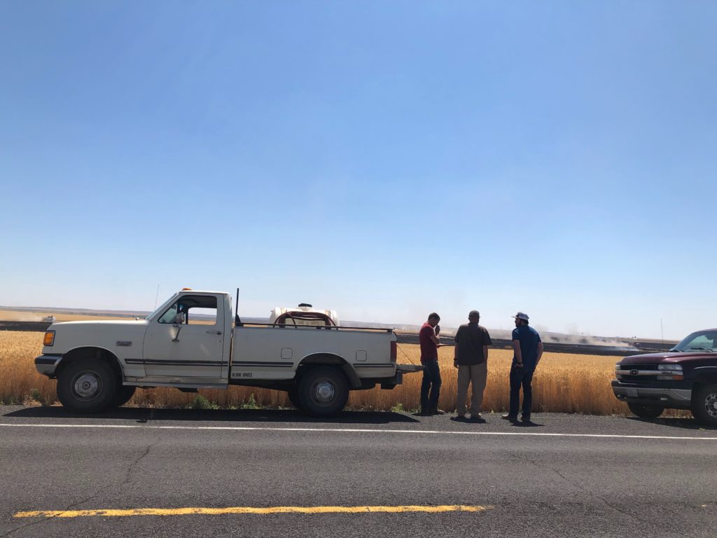 Several people in the area were gathered Thursday, July 25 to watch and assist with a fire burning in wheat and brush land near Washtucna. CREDIT: ANNA KING/N3
