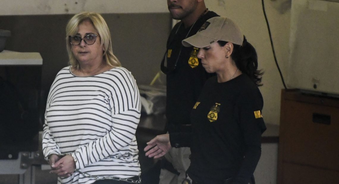 Federal agents escort former Puerto Rico Health Insurance Administration head Ángela Ávila-Marrero, who was arrested on Wednesday as part of a corruption investigation that resulted in an indictment against six defendants. CREDIT: Carlos Giusti/AP