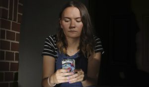 Rachel Whalen looks at her phone at her home in Draper, Utah. Whalen remembers feeling gutted in high school when a former friend would mock her online postings, threaten to unfollow or unfriend her on social media and post inside jokes about her to others online. CREDIT: RICK BOWMER/AP