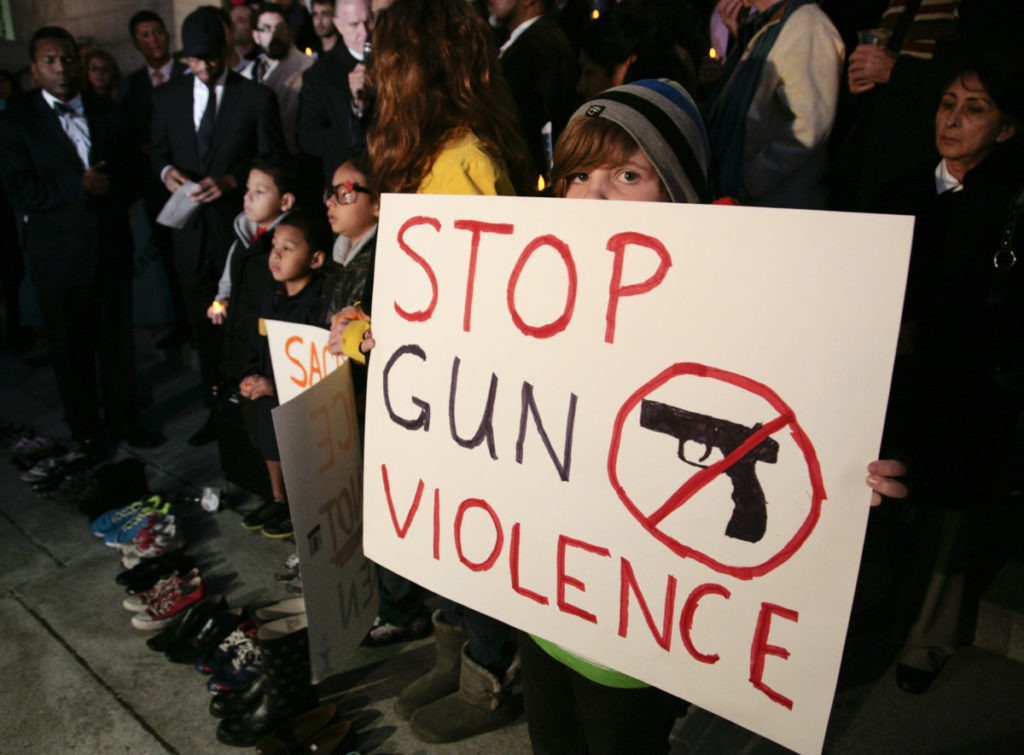 Sophie Bell, 9, holds a sign during an interfaith candlelight prayer vigil to end gun violence in front of Los Angeles City Hall in Los Angeles, California, December 19, 2012. A gunman killed 20 children and six adults in a shooting rampage at Sandy Hook Elementary School in Newtown, Connecticut on December 14. CREDIT: Jason Redmond/Reuters