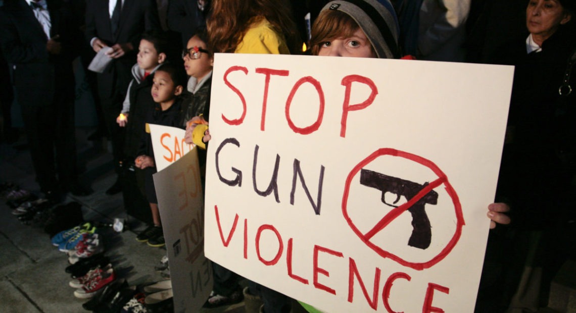 Sophie Bell, 9, holds a sign during an interfaith candlelight prayer vigil to end gun violence in front of Los Angeles City Hall in Los Angeles, California, December 19, 2012. A gunman killed 20 children and six adults in a shooting rampage at Sandy Hook Elementary School in Newtown, Connecticut on December 14. CREDIT: Jason Redmond/Reuters