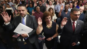 New citizens take the oath of allegiance during a naturalization ceremony in Oakland Park, Fla., earlier this year. The Trump administration has announced there will be changes to the U.S. citizenship test. CREDIT: Wilfredo Lee/AP