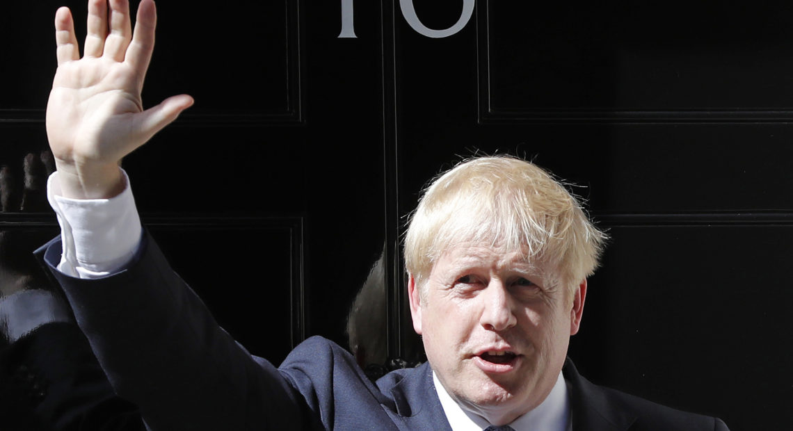 Boris Johnson waves outside 10 Downing Street in London on Wednesday. The polarizing and showboating new prime minister has vowed to deliver on the U.K. leaving the European Union in October, whether or not a deal is reached. CREDIT: Frank Augstein/AP