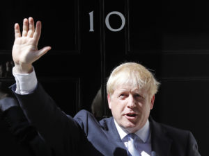 Boris Johnson waves outside 10 Downing Street in London on Wednesday. The polarizing and showboating new prime minister has vowed to deliver on the U.K. leaving the European Union in October, whether or not a deal is reached. CREDIT: Frank Augstein/AP