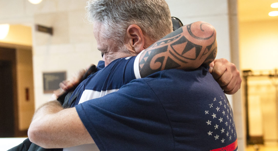 Sept. 11 first responder John Feal (left) and Jon Stewart, former host of The Daily Show, hug after the Senate passed a bill for extending the September 11th Victim Compensation Fund in Washington on Tuesday. Caroline Brehman/CQ-Roll Call