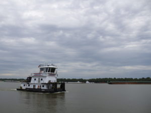 The Shawnee Forest towboat steers down the Ohio River near American Commercial Barge Line's office outside Cairo, Ill. As of June 12, more than 600 barges were waiting to go upstream once water levels dropped.. CREDIT: Madelyn Beck/Illinois Newsroom