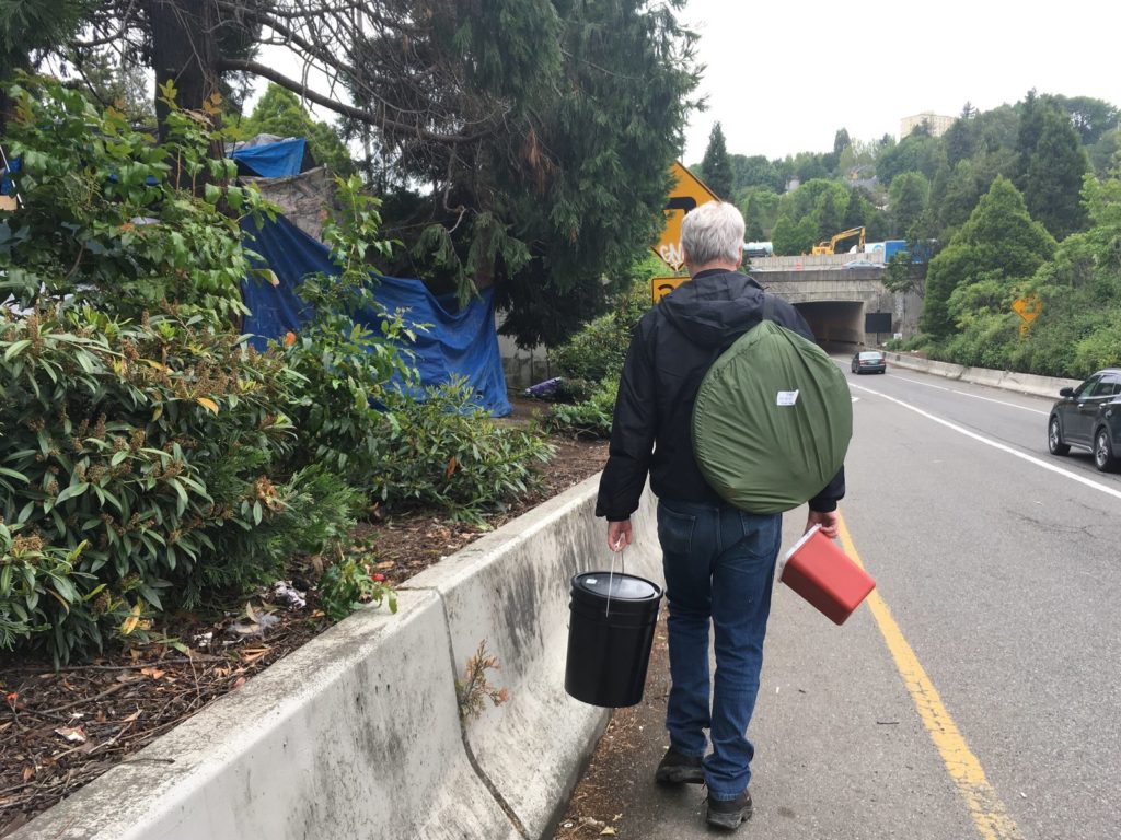 Seattle tech worker Mark Lloyd navigates the city's homeless encampments, giving away toilet kits and connecting with people. Gabriel Spitzer /KNKX