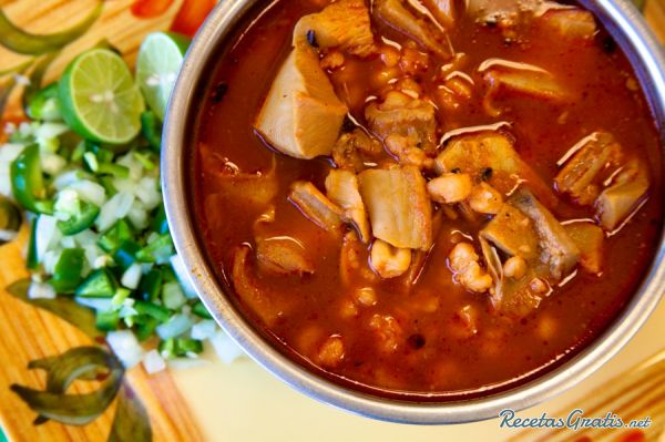 Bowl of menudo with onion and cilantro on the side.