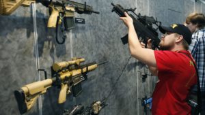 A visitor peruses H&K rifles at the SHOT Show in Las Vegas. Such weapons were once restricted under a 1994 ban that expired with changing politics in the United States. John Locher/AP