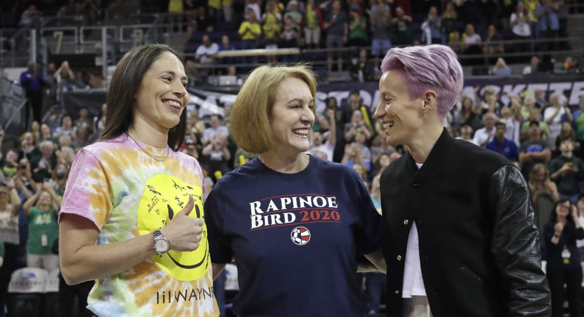 Seattle Mayor Jenny Durkan, center, wears a T-shirt honoring Megan Rapinoe, right, of the U.S. women's World Cup champion soccer team and the Seattle Storm's Sue Bird, left, before a WNBA game on July 12. Elaine Thompson/AP