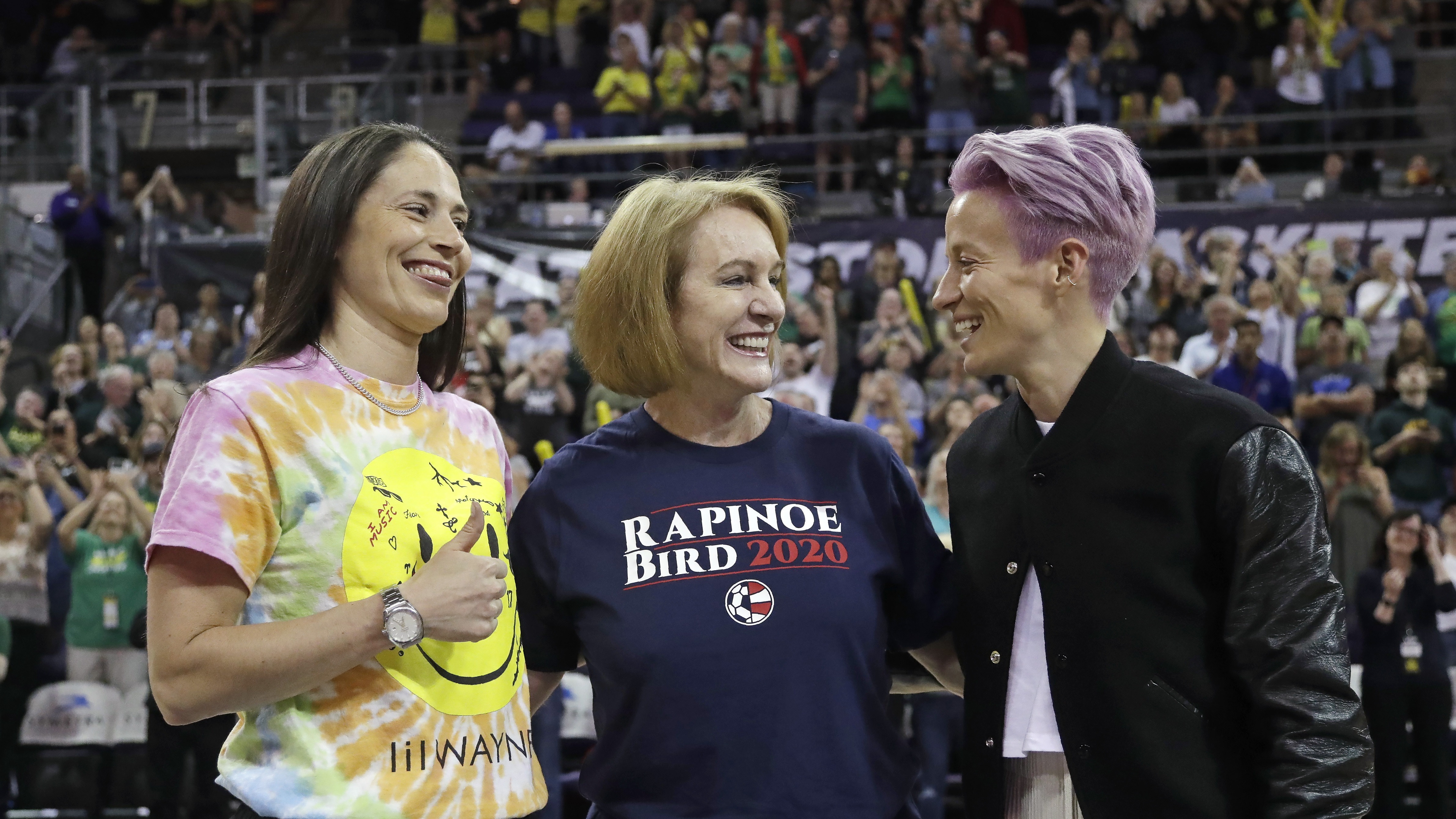 Seattle Mayor Jenny Durkan, center, wears a T-shirt honoring Megan Rapinoe, right, of the U.S. women's World Cup champion soccer team and the Seattle Storm's Sue Bird, left, before a WNBA game on July 12. Elaine Thompson/AP