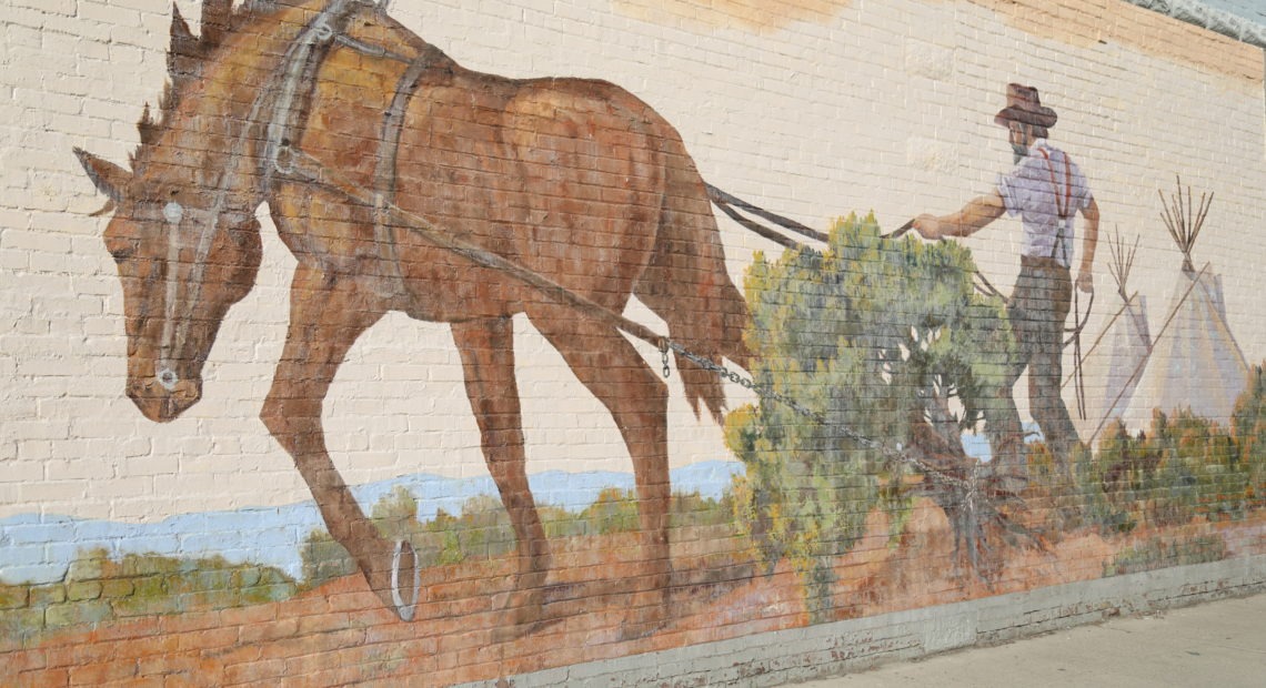 A horse and man plowing the land in Toppenish's first mural.