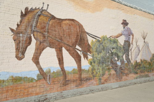 A horse and man plowing the land in Toppenish's first mural.