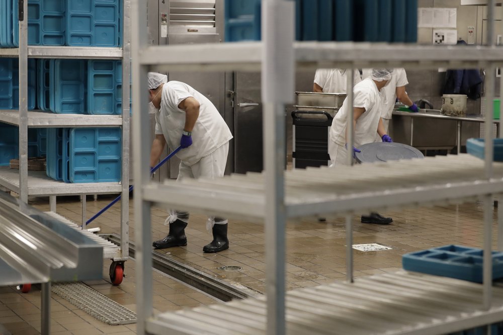 In this photo taken Sept. 10, 2019, workers are shown in the kitchen of the U.S. Immigration and Customs Enforcement (ICE) detention facility in Tacoma, Wash. during a media tour. On Tuesday, Sept. 24, 2019, U.S. District Judge Robert Bryan notified attorneys for Washington state and the GEO Group -- which operates the detention center -- that he plans to dismiss a case in which Washington state was pursuing a claim that immigration detainees must be paid minimum wage for work they perform in custody. CREDIT: TED S. WARREN/AP