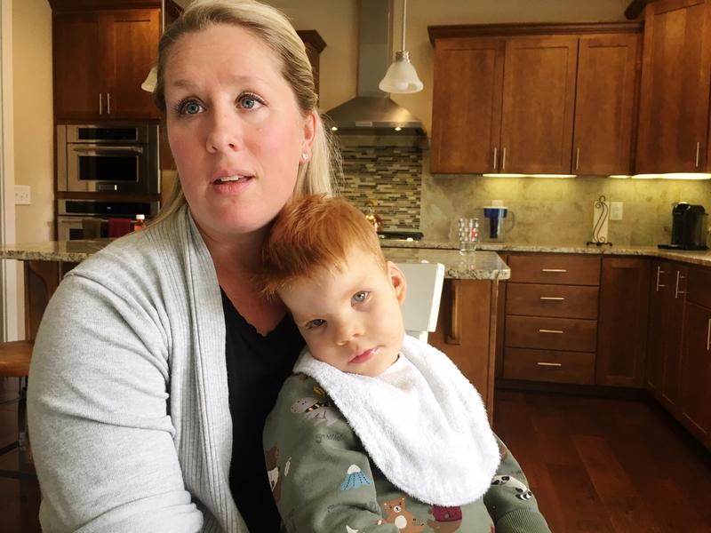 Lindsey Topping-Schuetz holds her nearly three-year-old son Owen who qualifies for developmental disabilities services, but has been denied them because of a lack of state funding. CREDIT: AUSTIN JENKINS / N3