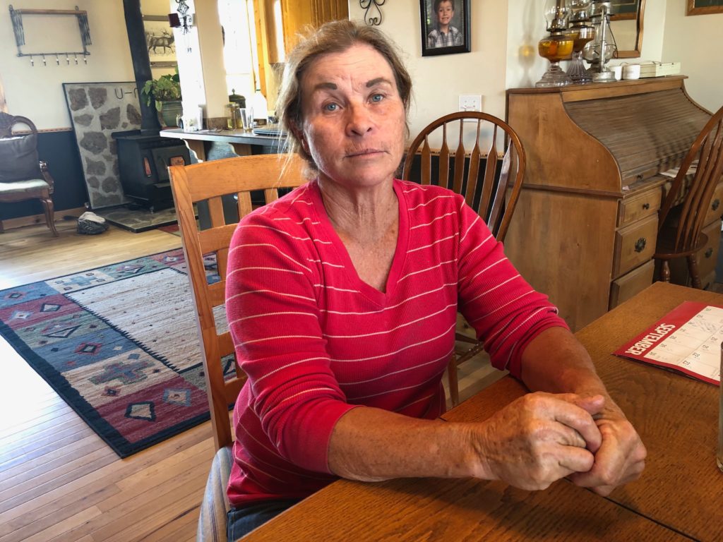 Andie Davies, of Princeton, Oregon, sits at her kitchen table taking a short break from canning chili peppers. Davies and her husband had one of their mother cows killed about two years ago in a mysterious way. The cow’s udder was precisely removed and the killer left no tracks. CREDIT: ANNA KING/N3