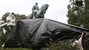 City workers drape a tarp over the statue of Confederate General Robert E. Lee in Charlottesville, Va. on Aug. 23, 2017. Steve Helber/AP