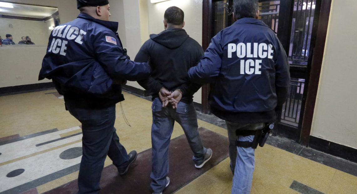 In this March 3, 2015, photo, Immigration and Customs Enforcement officers escort an arrestee in an apartment building in the Bronx borough of New York during a series of early morning raids. Richard Drew/AP